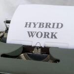 Close-up of a vintage typewriter with the text 'Hybrid Work' on paper, symbolizing modern work trends.
